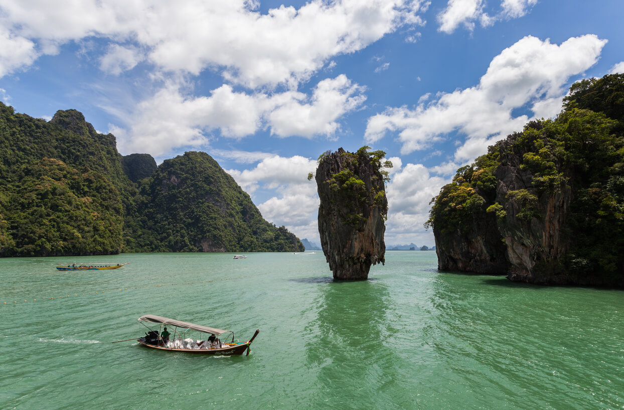 James Bond Island in Phang Nga with a longtail boat riding through the water
