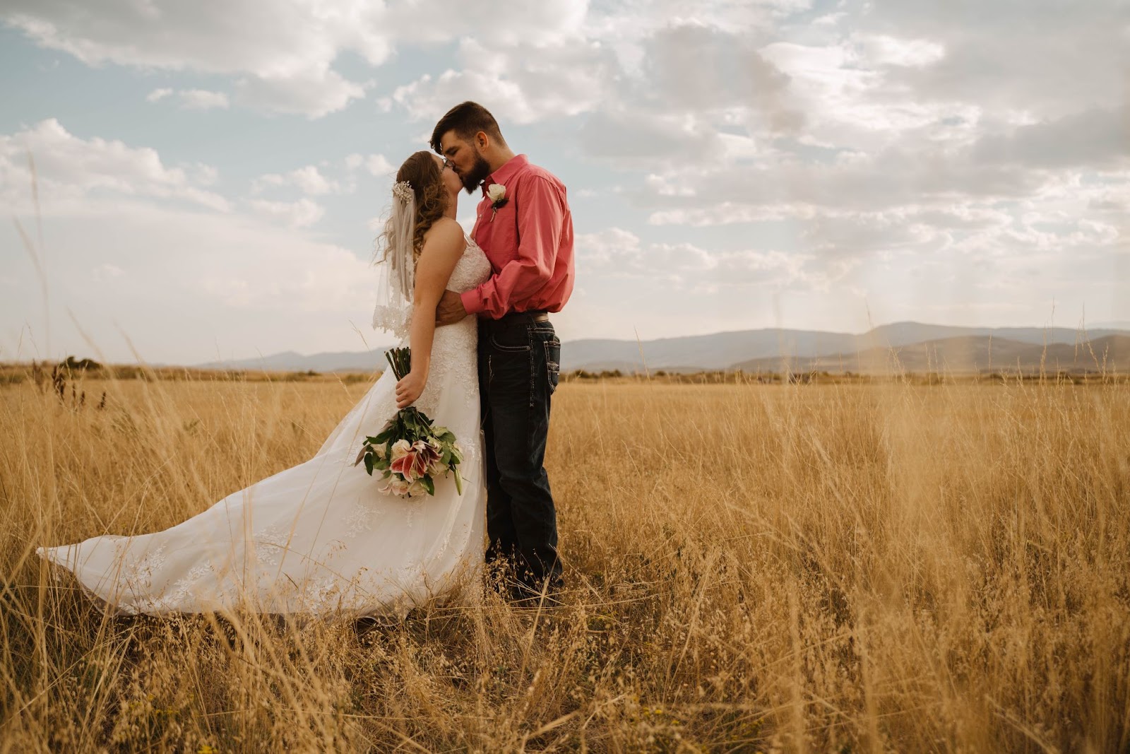 bride and groom kissing in the field at The Covey in Fort Collins, CO