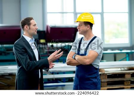 A businessman telling his worker to read instruction 