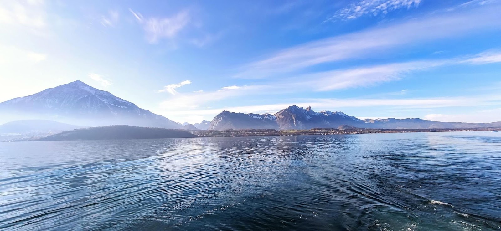 1 day in Interlaken, Lake Thun, panoramic view of Lake Thun, clear blue skies with snow capped mountains in the background