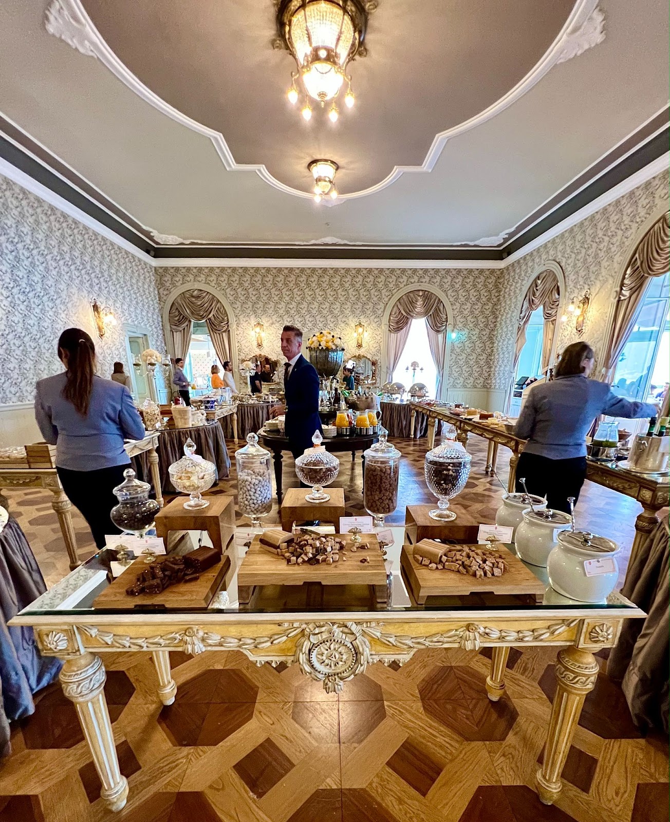 a group of people standing around a table with food on it