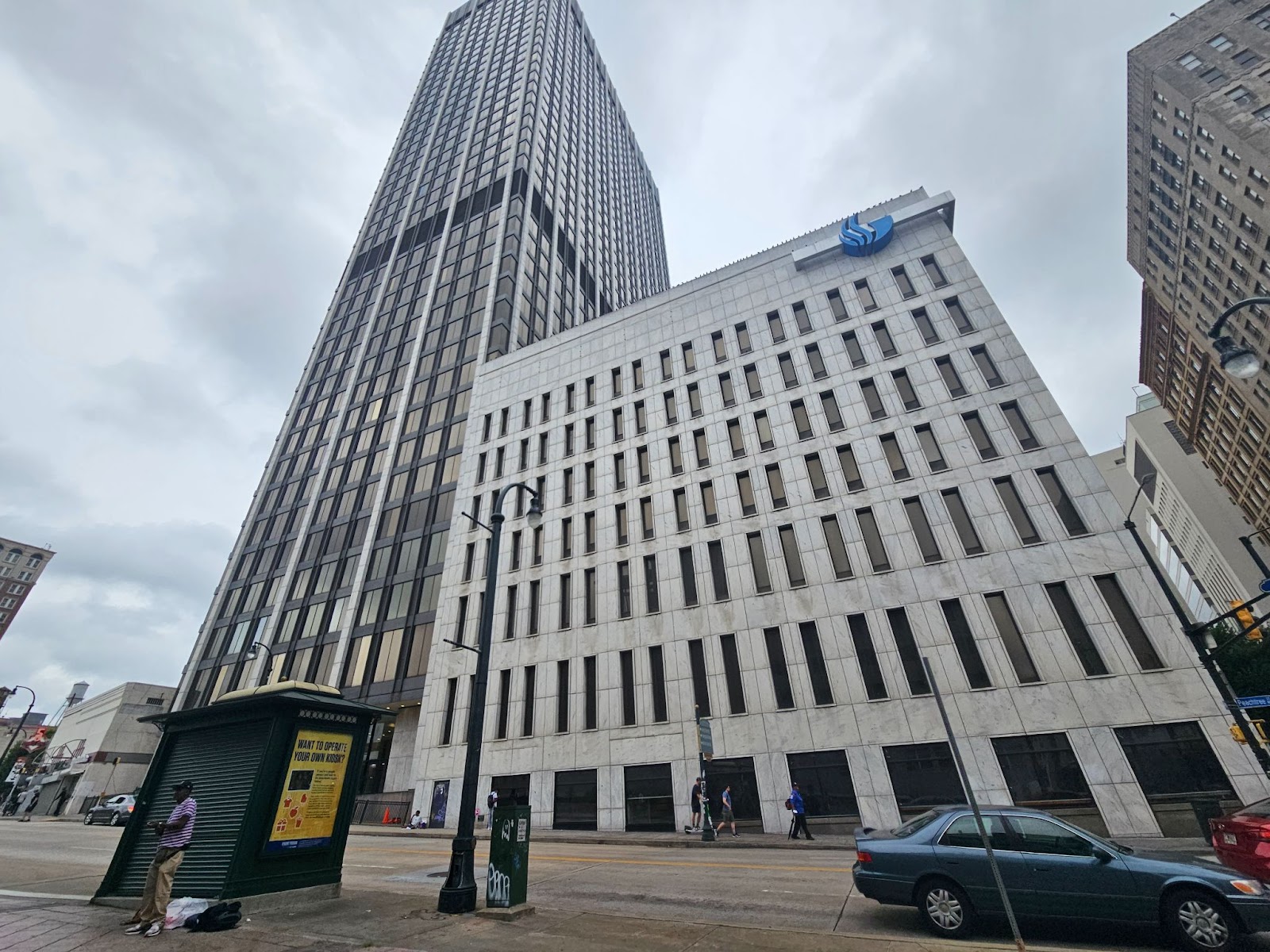 A photo from the street shows the white GSU office building and the glassy black Two Peachtree skyscraper towering above it.