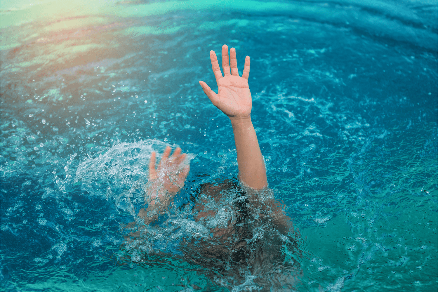 Swimmer underwater showing clear signs of distress with their arms above water