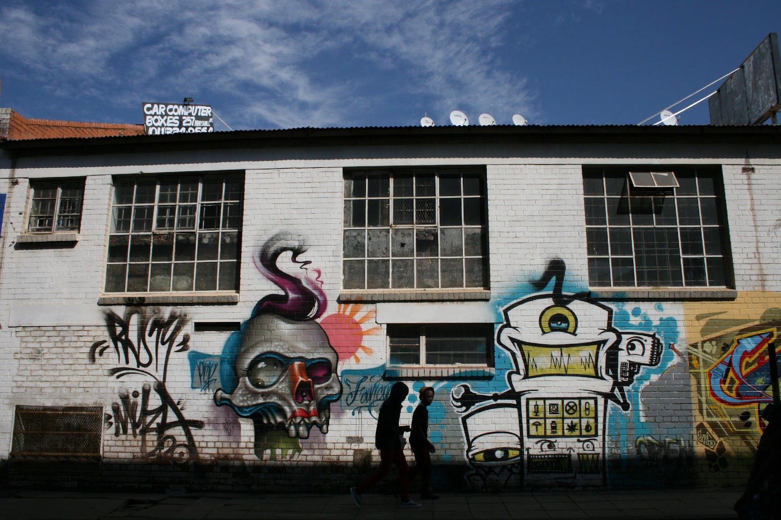 A group of people standing in front of a building with graffiti

Description automatically generated with medium confidence