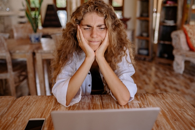 a woman makes a face while looking at a suspiciously low quote for moving services