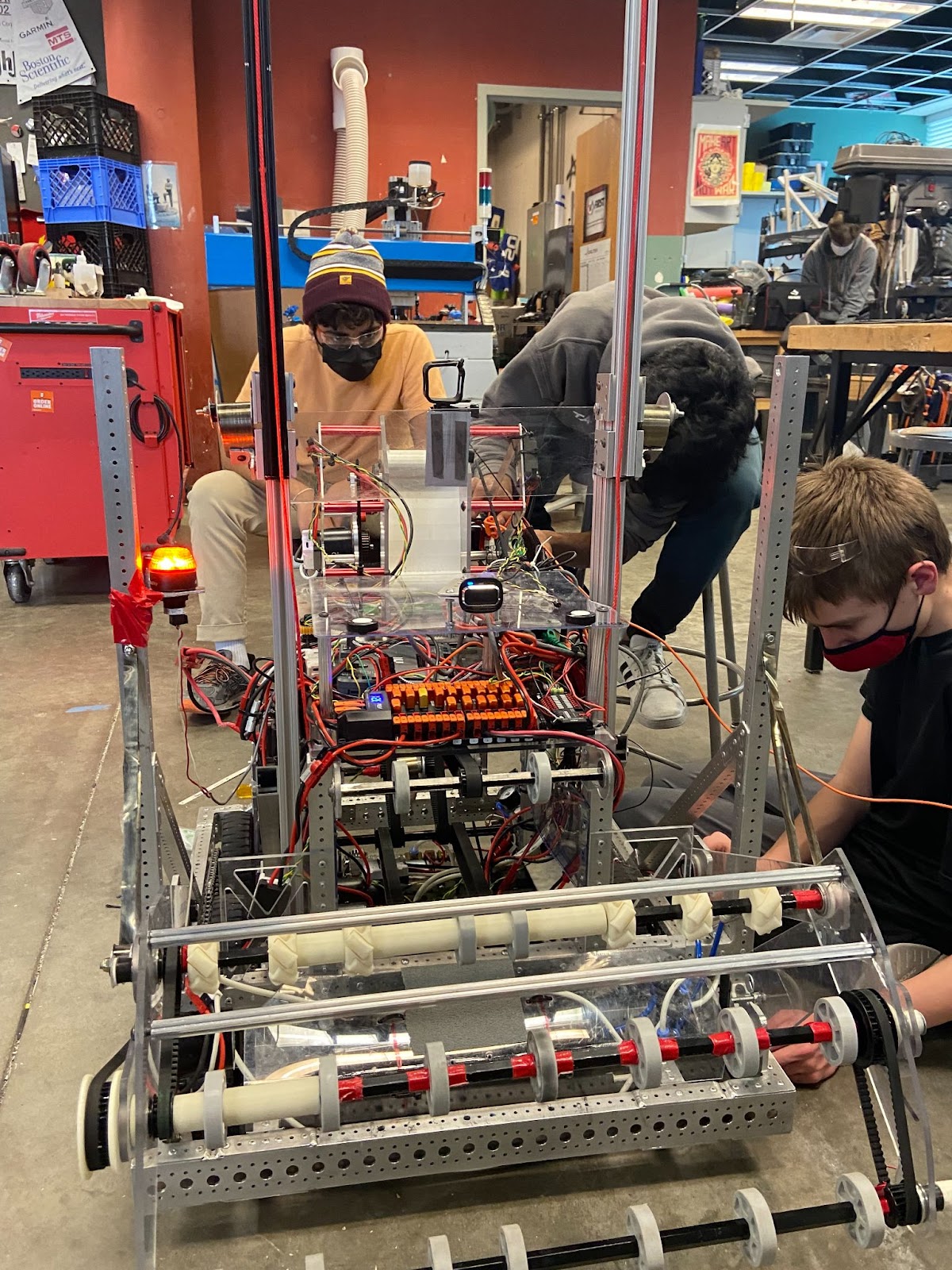 Three students working on the robot in the open room