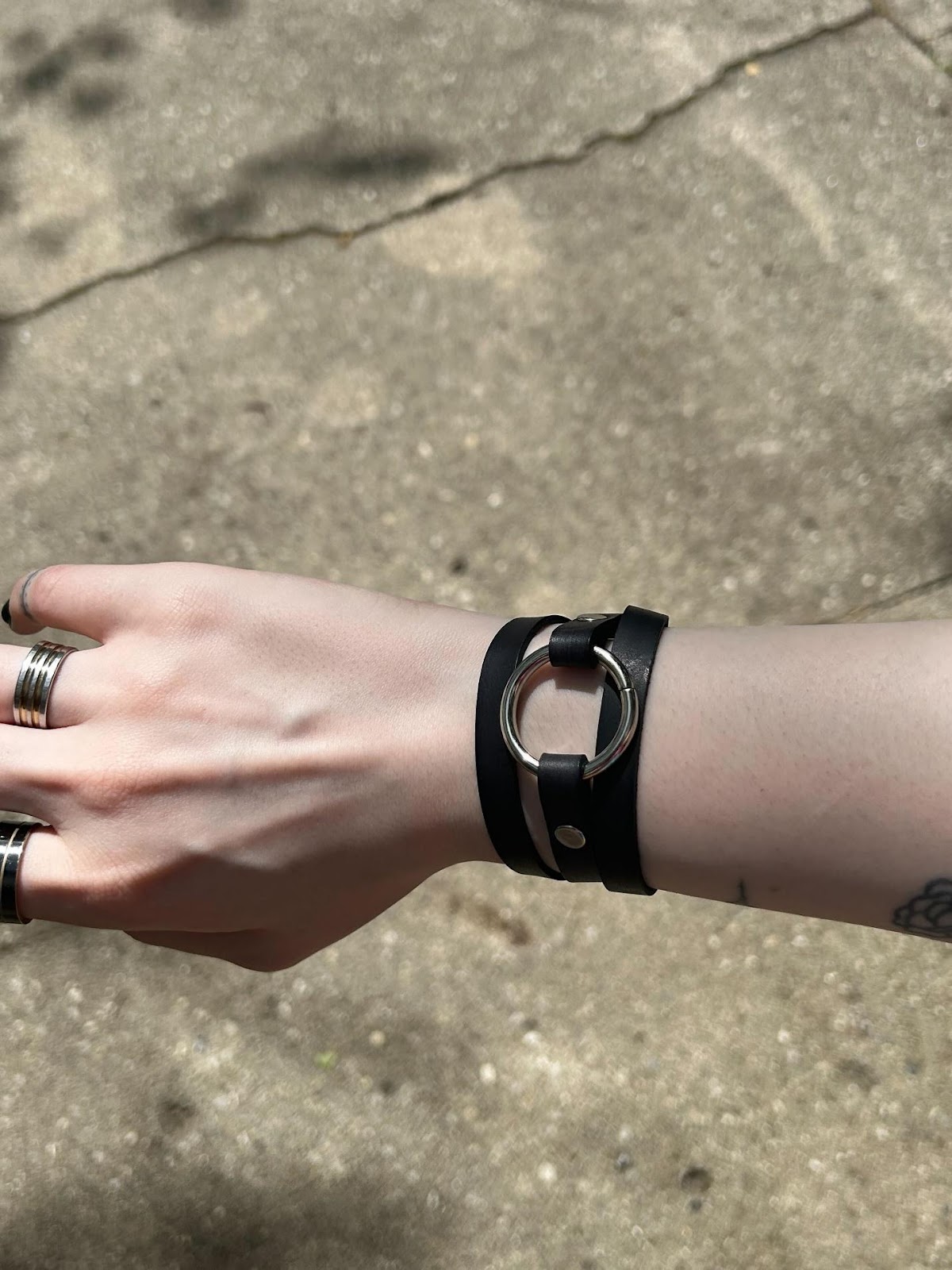 A hand with a leather bracelet

Description automatically generated