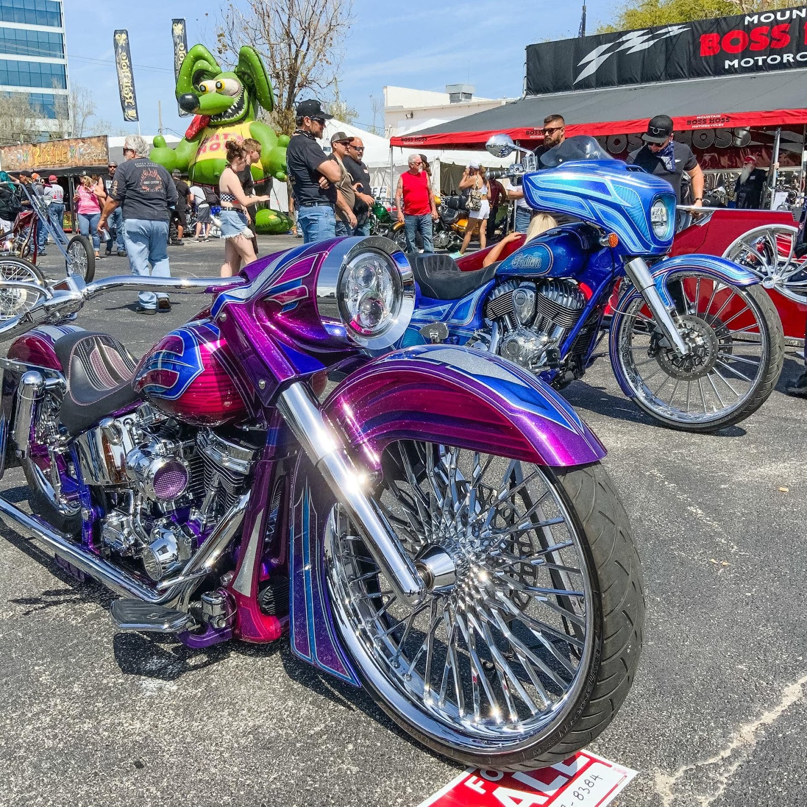 This customized chopper in fuchsia and blue with spoked, shiny, chrome wheels is shown at the 80th Daytona Bike Week.