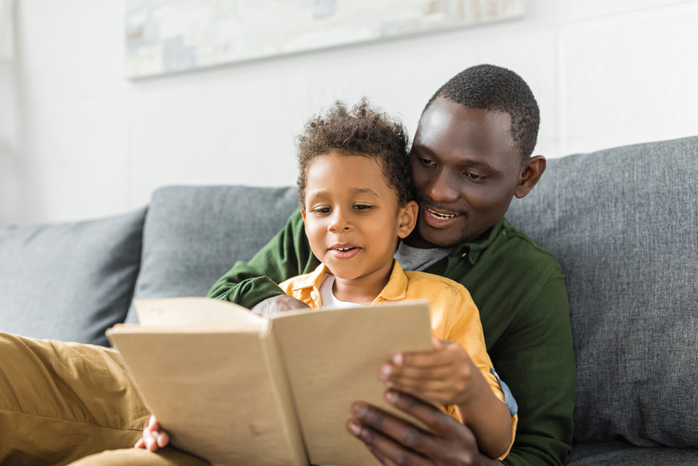 Parent teaching adjectives for kids by reading to his son