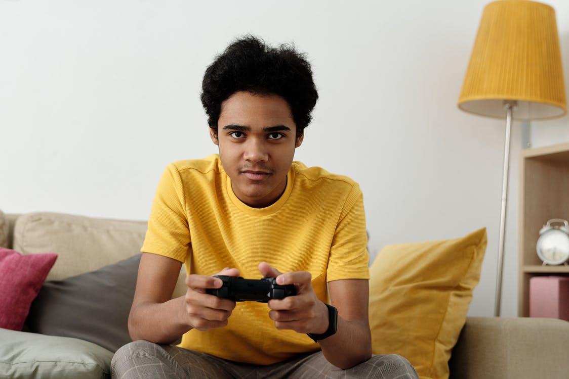 Man in Yellow Crew Neck T-shirt Sitting on Bed