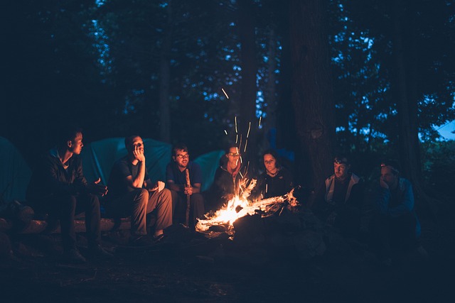 friends around a bonfire they made for things to do while camping with friends