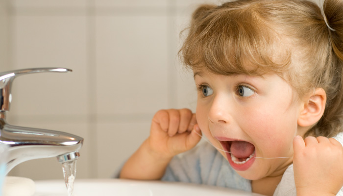 a child trying to floss