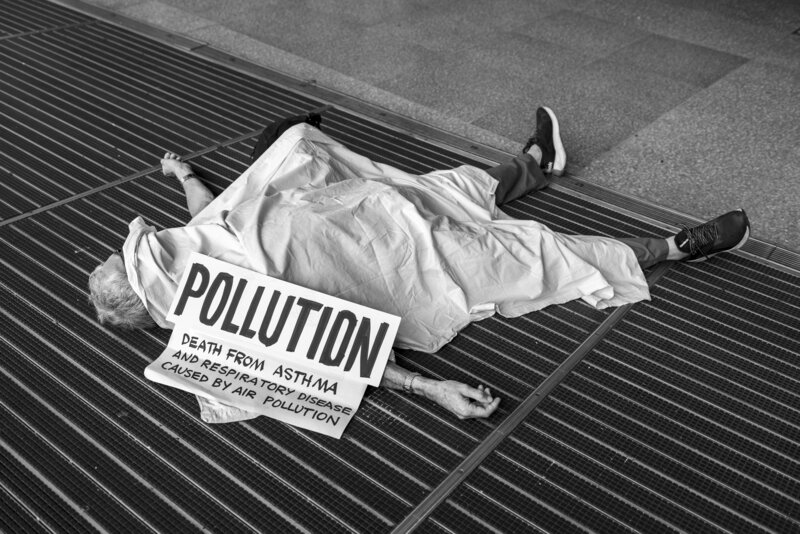 A Rebel lying on the floor with a sign "pollution, death from asthma and respiratory disease caused by air pollution"