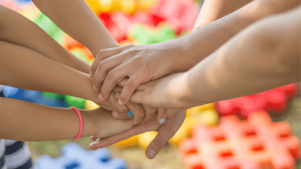 communication-non-violente-en-famille : sept personnes unissent leurs mains
