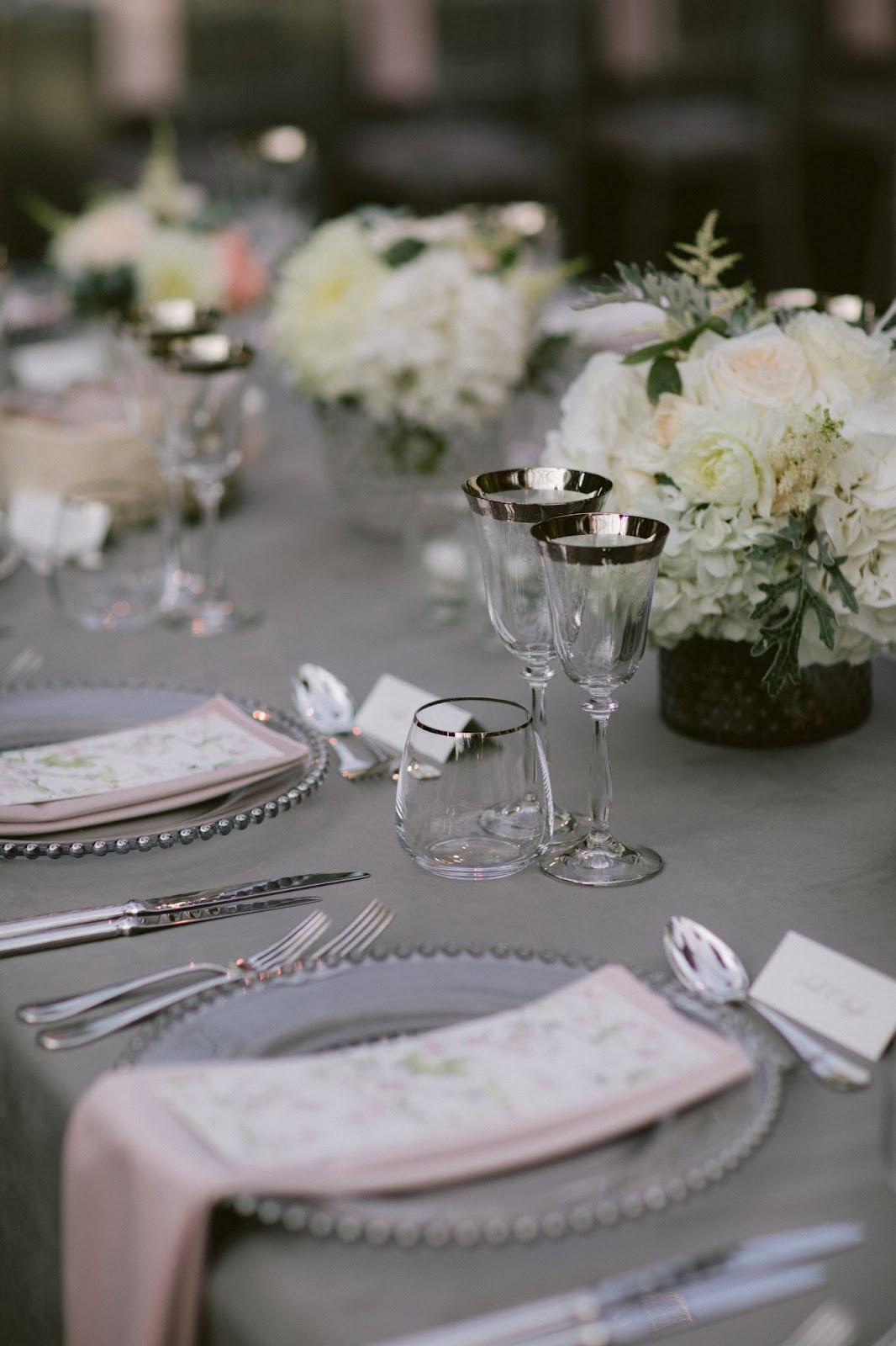 Table set up with silverware and white florals by Tara Fay.