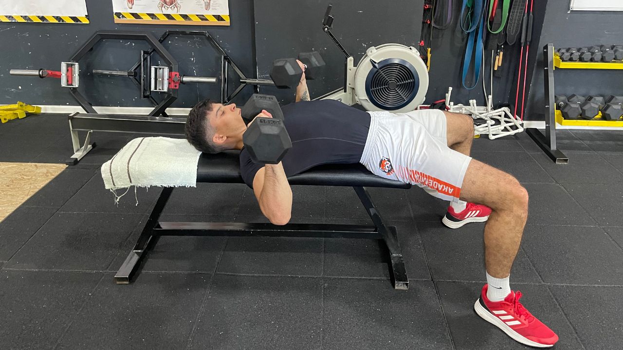 Vanja performs the dumbbell chest press on a flat bench.