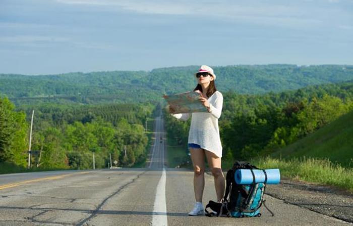 A person standing on the road looking at a map

Description automatically generated with medium confidence
