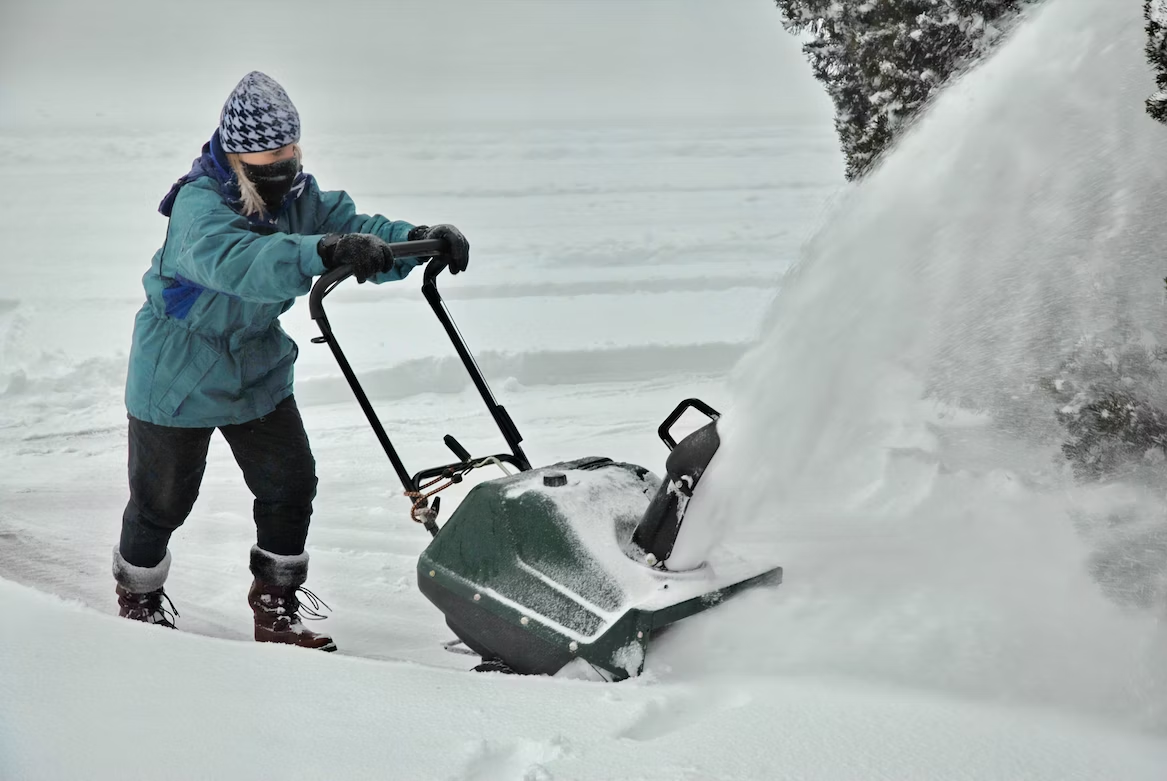 person clearing snow with snowblower