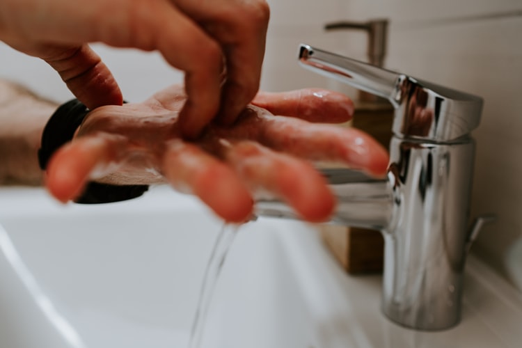 Pessoa lavando a mão para não ficar doente.