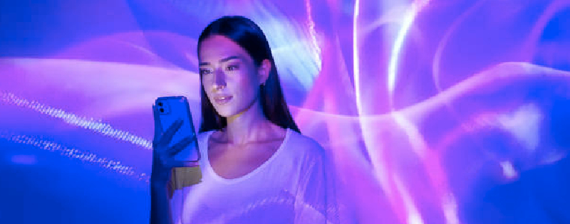 Woman holding her phone with neon lights around her