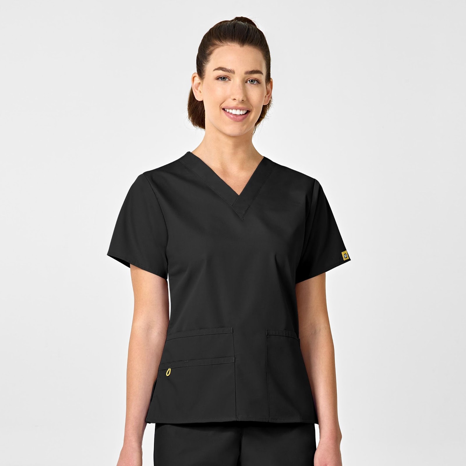 Model wearing Origins Bravo scrub top in the colour black.
