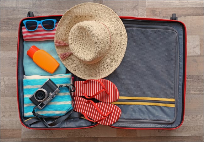 An open suitcase packed for a vacation.