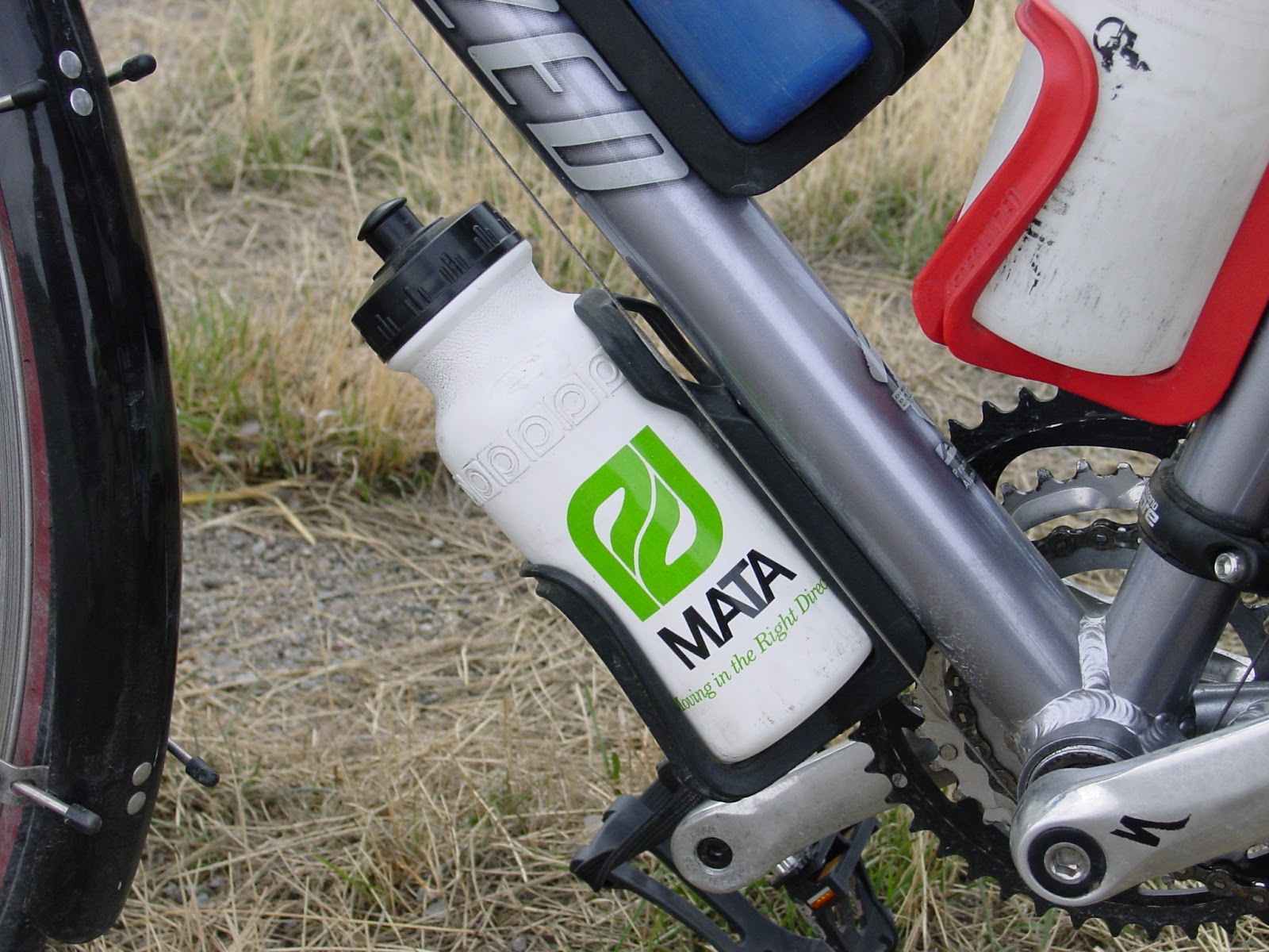The bottom water bottle on a bike frame that has a curves green logo and the letters: M A T A