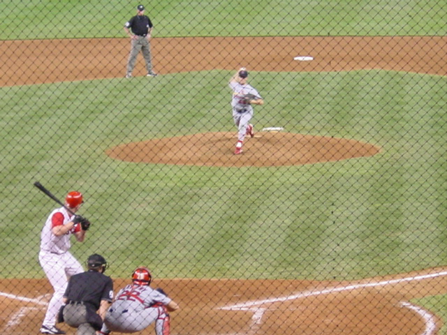 The pitcher is just about to release the ball as his arm comes forward.