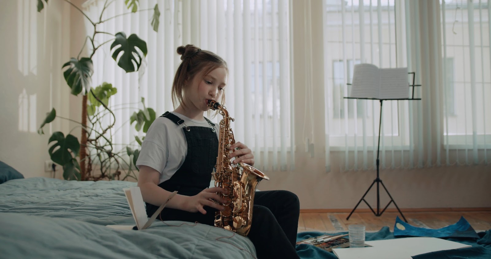 A young girl playing with a Saxophone
