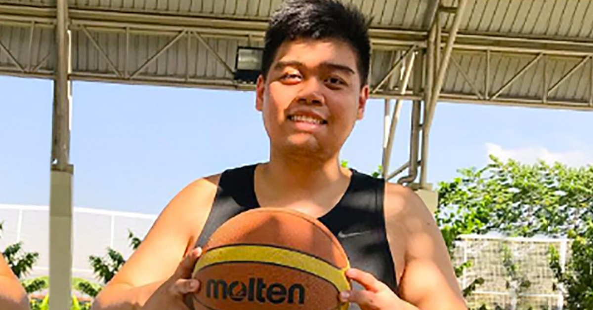 An athlete with an intellectual disability posing with his basketball