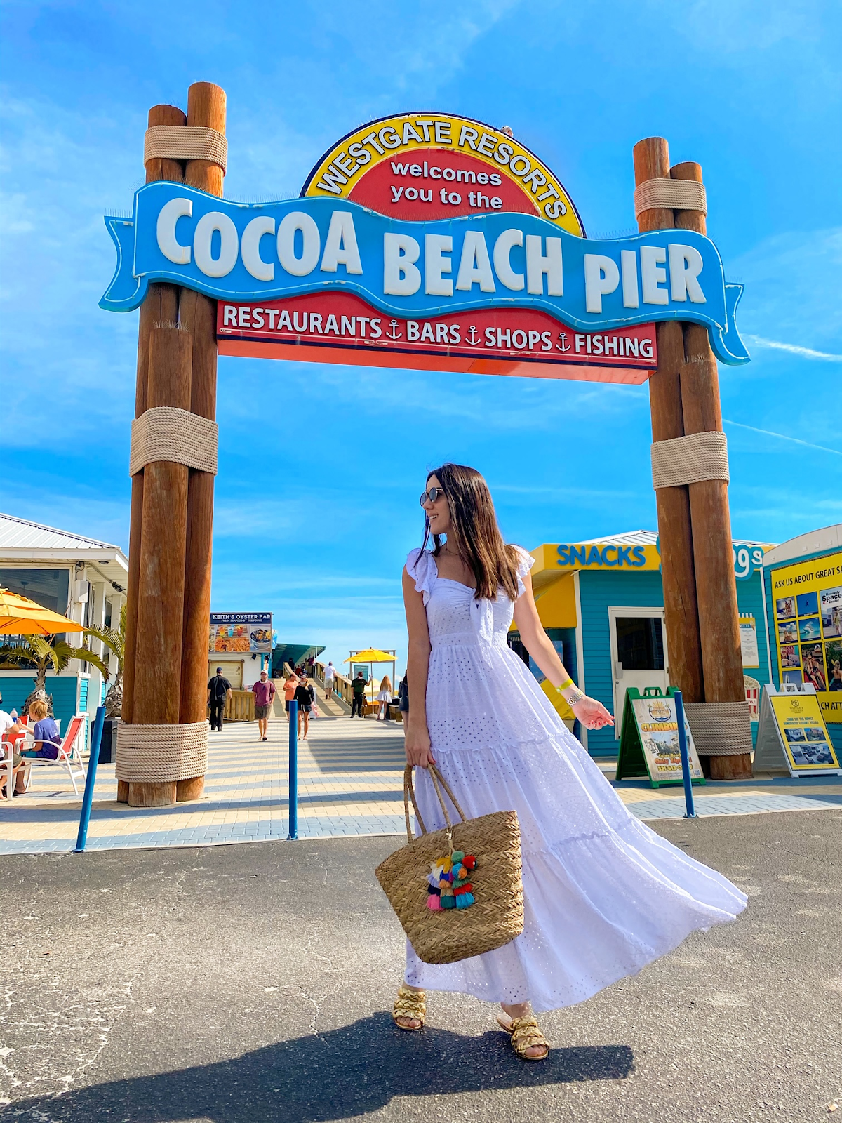 A person in a white dress in front of a sign

Description automatically generated with medium confidence