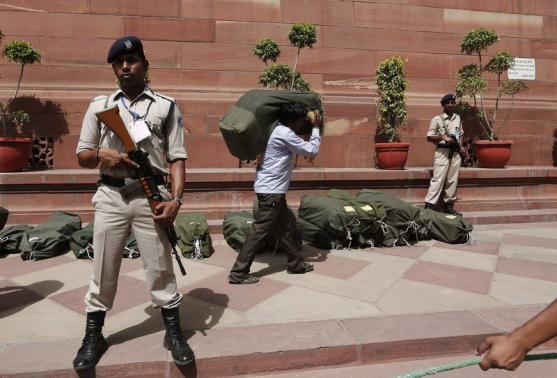 Security personnel stand guard near sacks containing the papers of the federal budget for the 2014-15 fiscal year, at the parliament in New Delhi July 10, 2014.  REUTERS-Adnan Abidi