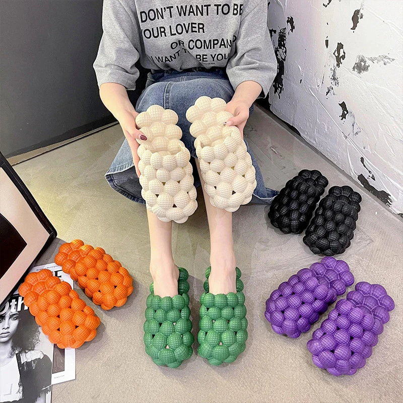 an Asian sitting with many bubble slippers around them