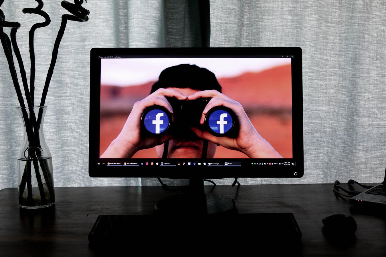 Verrekijker met Facebook logo's erop op een monitor
