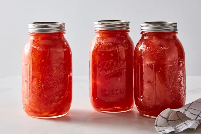 Three jars of canned preserved tomatoes