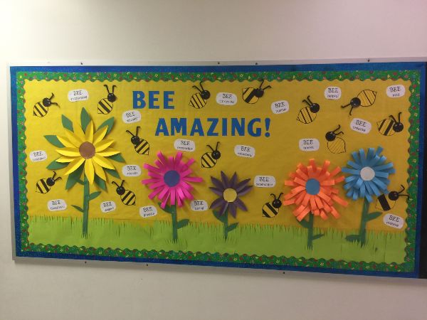 a bulletin board featuring five huge flowers, bumble bees, and good character traits scattered throughout the board.