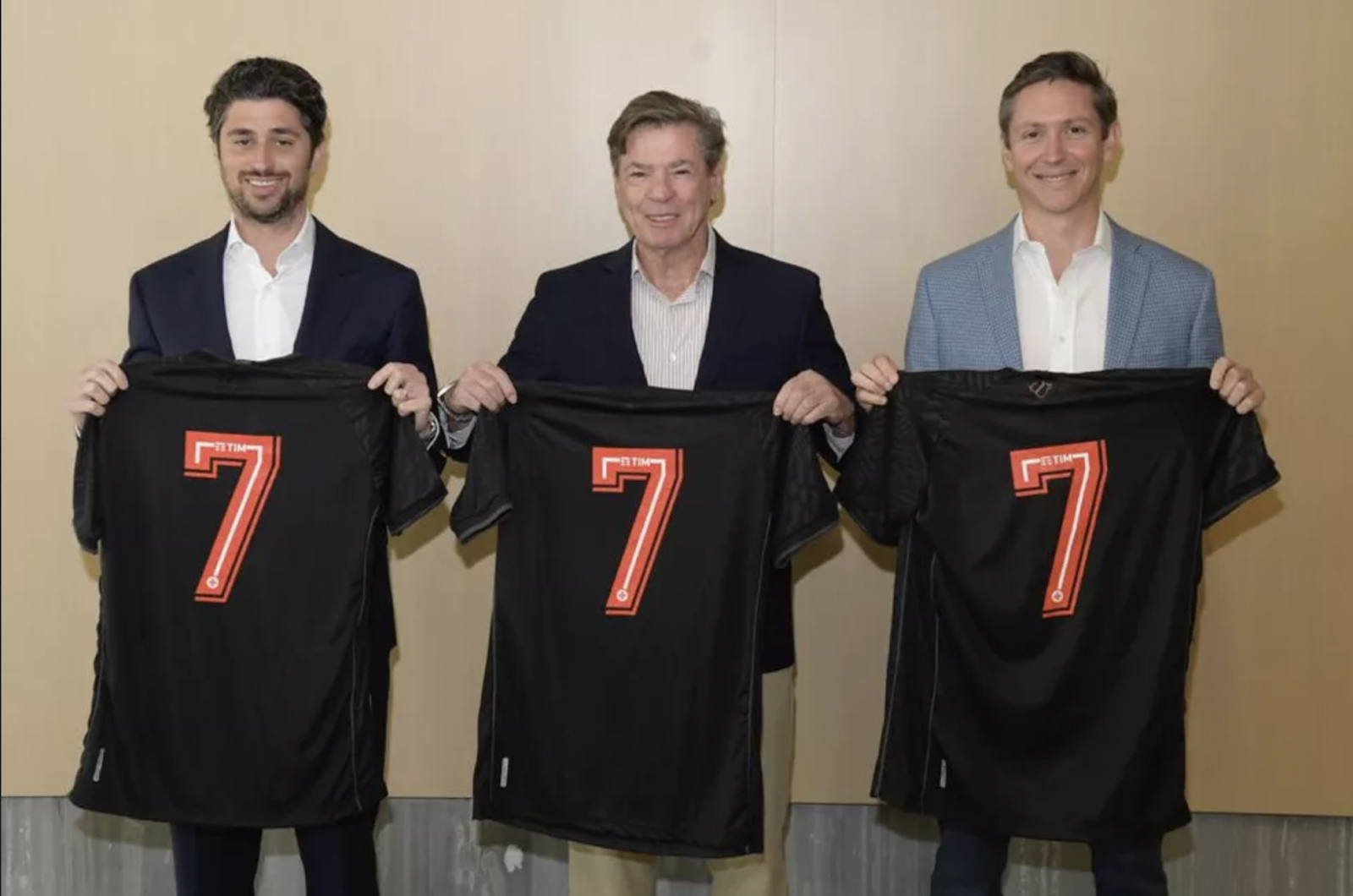 A group of men holding up black shirts with numbers

Description automatically generated with low confidence