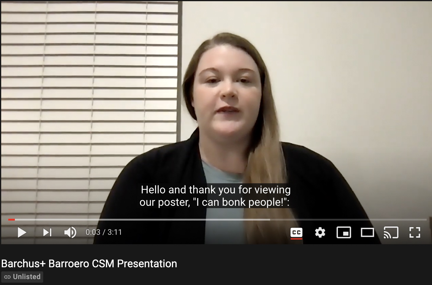 Still image of presentation. A woman with long blonde hair is speaking. Video controls are displayed.