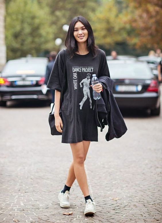 Girl wearing a black printed oversized t-shirt without any bottoms. 