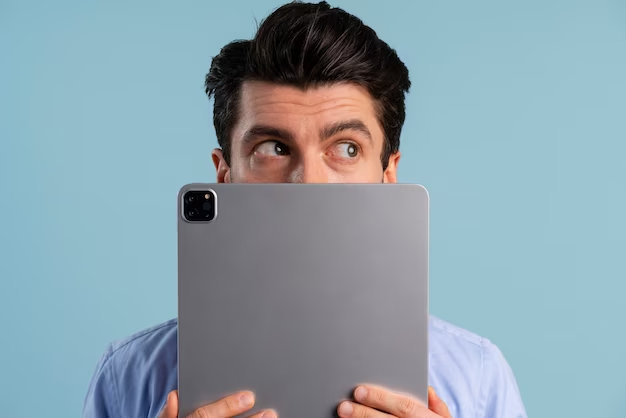A man covers his face with an iPad