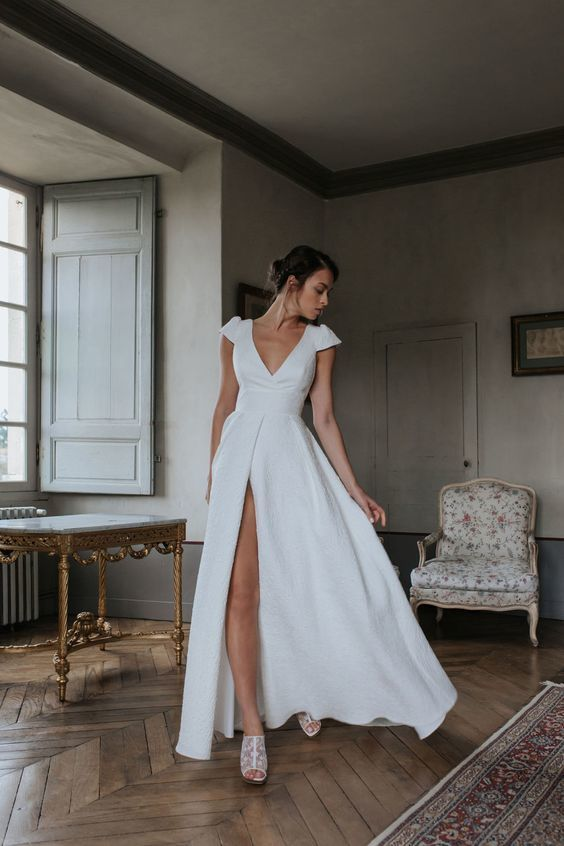 a lady wearing a  white dress with a thigh-high slit as casual wedding dresses