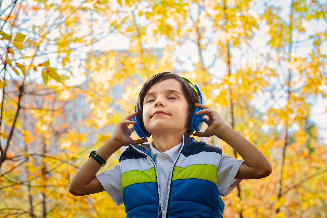 young boy listening to music through headphones