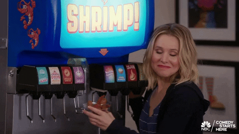 A gif of an a woman standing by a drink vending machine with the word 'Shrimp' on it and the caption reads: "This is the dream" and the woman is smiling because she's so pleased with the machine.
