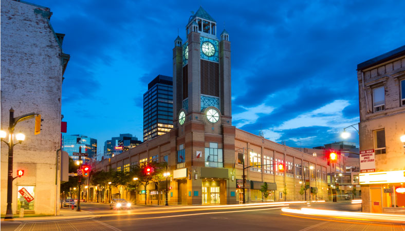 Hamilton City Centre shopping mall at dusk, with its clock tower on the corner of York Boulevard and James Street North in Downtown Hamilton, Ontario, Canada.