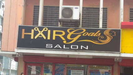 Sign for Hair Goals Hair Salon with scissors and womans profile, mounted on a building facade.