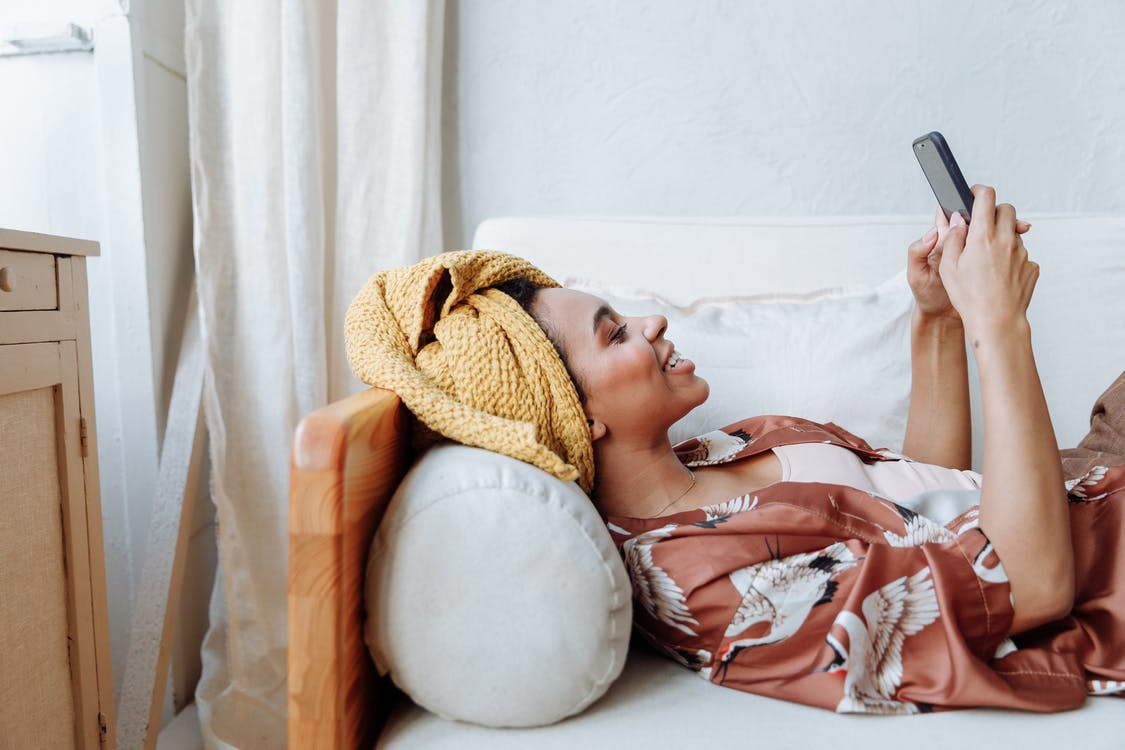 Woman in White and Brown Dress Lying on Bed