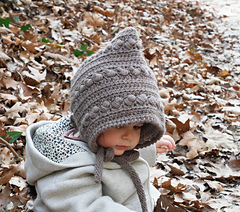 child wearing gray baby bonnet outside