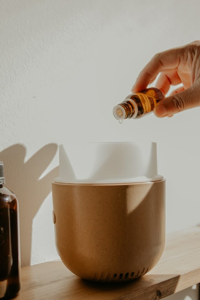 Adding Essential Oil to A Brown and White Diffuser
