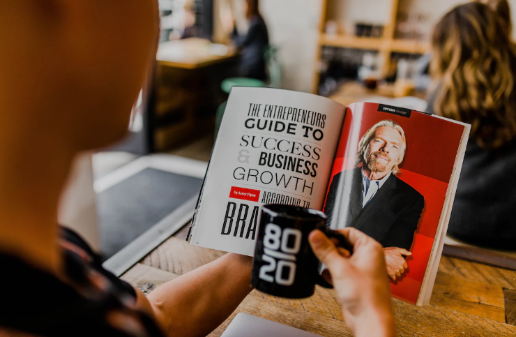 a man reading a Success book featuring Richard Branson