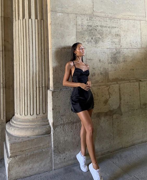 lady wearing little black dress with white sneakers
